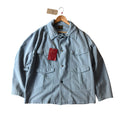 Light blue denim jacket with a red tag on a white background