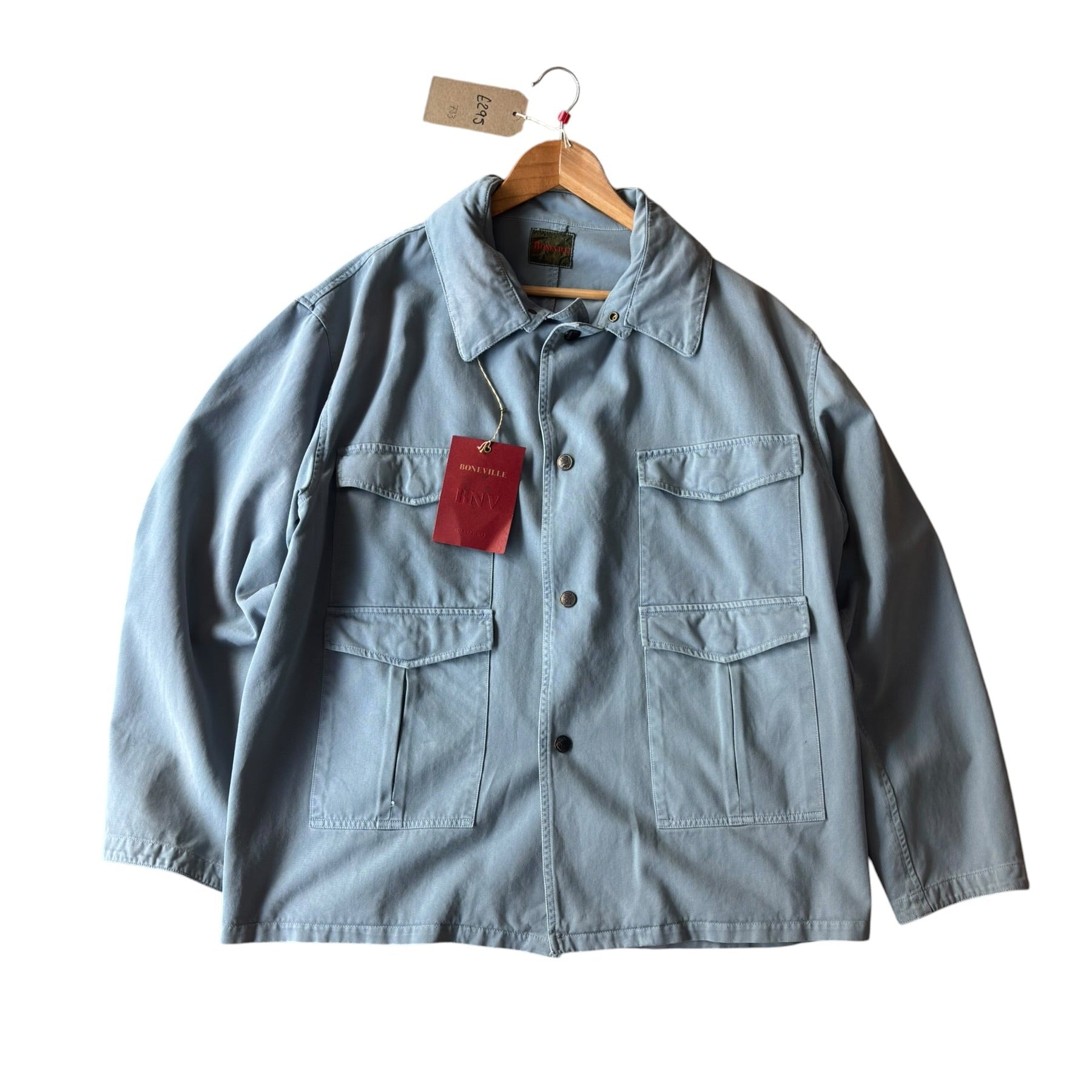 Light blue denim jacket with a red tag on a white background